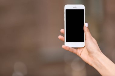 Dışarıda cep telefonu olan genç bir kadın.