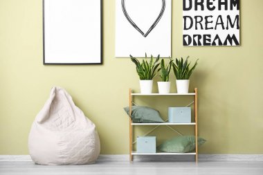 Renkli duvara yakın rahat beanbag ve raf ünitesi