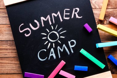 Ahşap masada metin yaz kampı ve boya kalemi ile Chalkboard