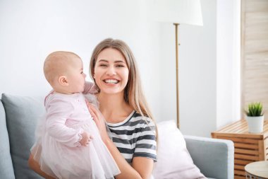 Mutlu anne ve evde küçük şirin bir bebek.