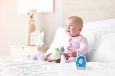 Küçük çocuk ile yatakta modern bebek monitörü