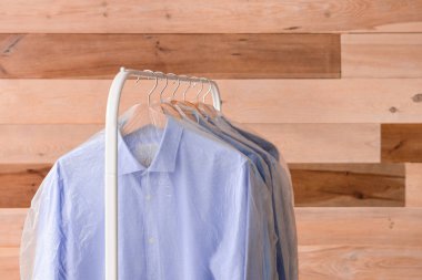 Ahşap arka planda kuru temizledikten sonra giysi ile raf