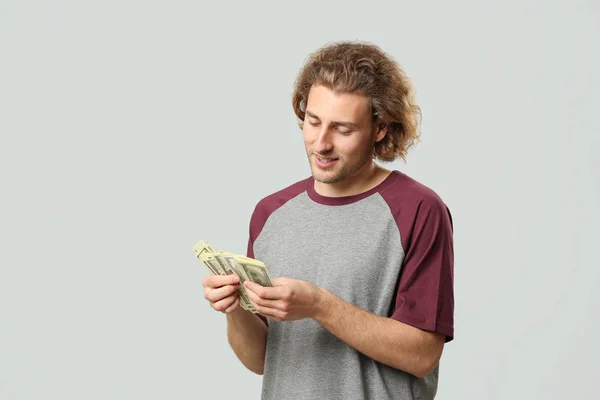 Hombre guapo con dinero sobre fondo gris — Foto de Stock