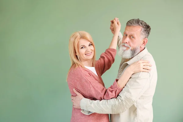 Dancing elderly couple on color background — Stock Photo, Image