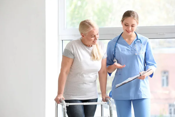 Asistente médico explicando a la mujer madura su diagnóstico en clínica — Foto de Stock