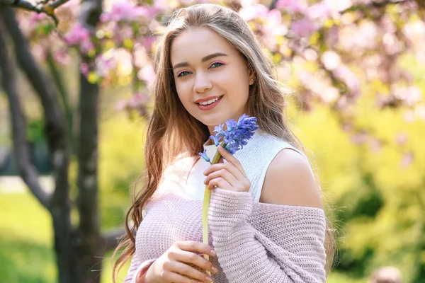 Beautiful young woman with hyacinth flowers outdoors — Stock fotografie