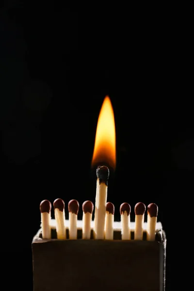 Box with matches and flame on dark background — Stock Photo, Image