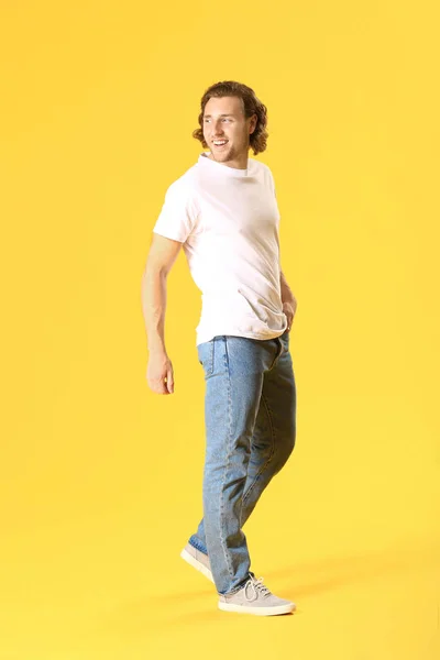 Stylish young man in jeans on color background — Stock Photo, Image