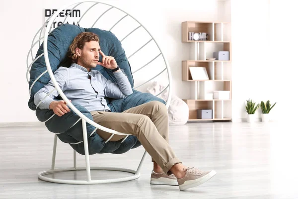 Elegante joven sentado en sillón en casa — Foto de Stock