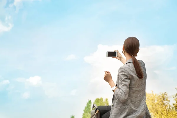 Ung kvinna med mobil telefon ta foto utomhus — Stockfoto
