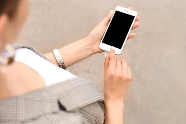 Young woman with mobile phone outdoors — Stock Photo, Image