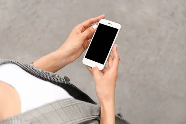 Young woman with mobile phone outdoors — Stock Photo, Image