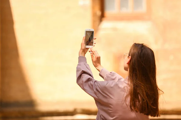 Mujer joven con teléfono móvil tomando fotos al aire libre — Foto de Stock