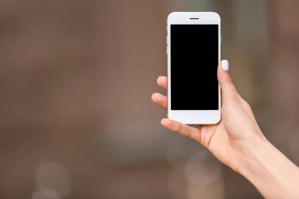 Young woman with mobile phone outdoors — Stock Photo, Image