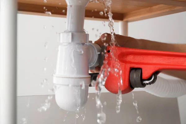 Plumber repairing pipes of kitchen sink, closeup — Stock Photo, Image