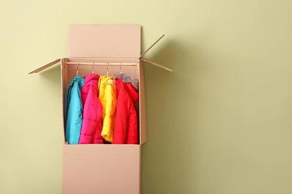 Armoire boîte avec des vêtements sur fond de couleur — Photo