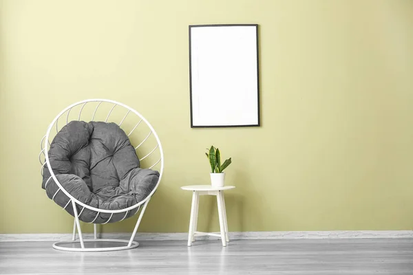 Comfortable armchair and table near color wall — Stock Photo, Image