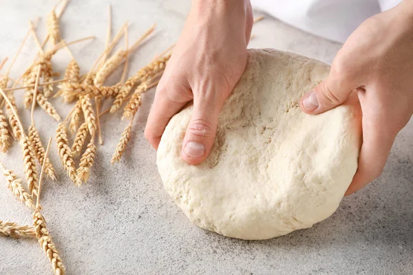 Man kneading dough on kitchen table, closeup — Stock Photo, Image