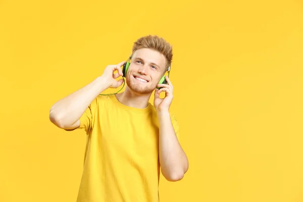 Πορτρέτο του ευτυχισμένο νεαρό άντρα ακούγοντας μουσική στο φόντο του χρώματος — Φωτογραφία Αρχείου
