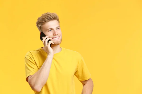 Πορτρέτο του ευτυχισμένο νεαρό άντρα που μιλά από το κινητό τηλέφωνο στο χρώμα φόντου — Φωτογραφία Αρχείου