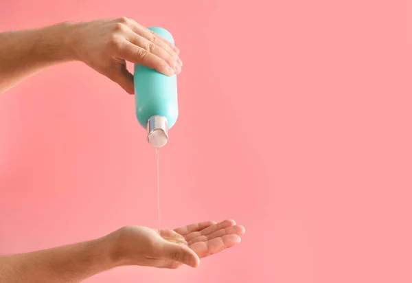 Männliche Hände mit einer Flasche Shampoo auf farbigem Hintergrund — Stockfoto