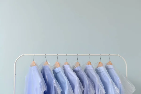 Стелаж з одягом після хімчистки на світлому фоні — стокове фото