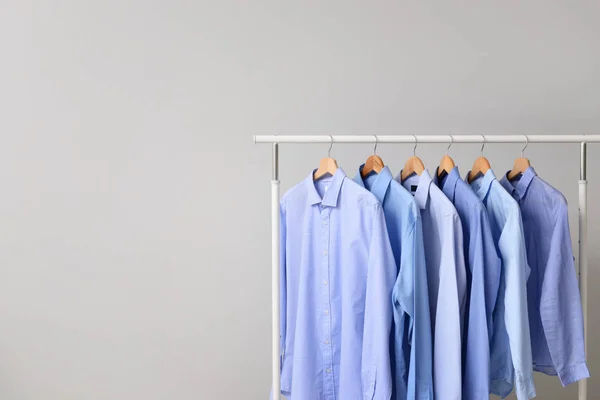 Cremalheira com roupas após a limpeza a seco em fundo claro — Fotografia de Stock