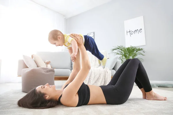 Mother training with cute little baby at home — Stock Photo, Image