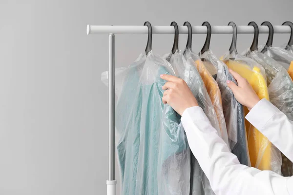 Wanita tergantung pakaian di rak setelah dry-cleaning — Stok Foto