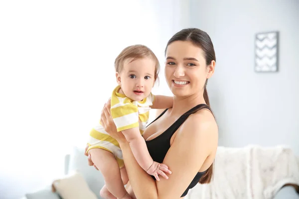 Deportiva mujer con lindo bebé en casa —  Fotos de Stock
