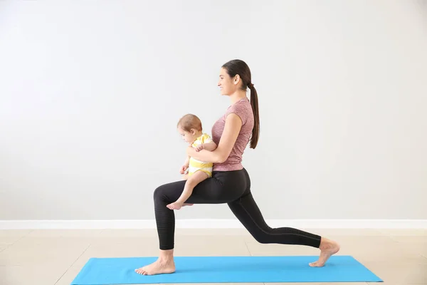 Mother training with cute little baby indoors — Stock Photo, Image