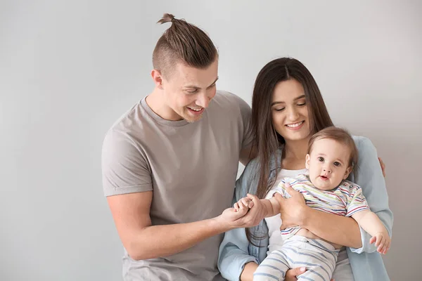 Padres felices con lindo bebé sobre fondo claro —  Fotos de Stock