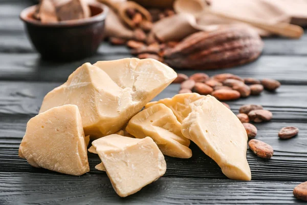 Kousky kakaového másla na dřevěný stůl — Stock fotografie