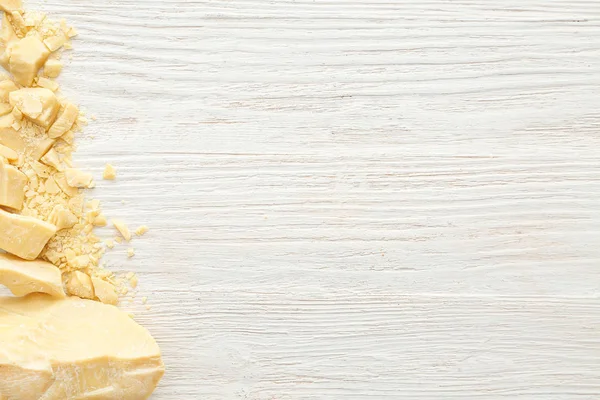 Pedaços de manteiga de cacau na mesa de madeira branca — Fotografia de Stock