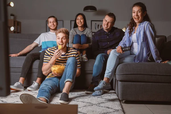 Amigos viendo la televisión en casa por la noche — Foto de Stock