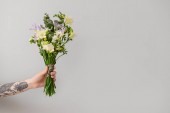 Női kéz gyönyörű Freesia virágok világos háttér