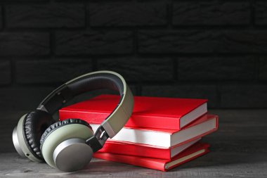 Masa üzerinde kitaplar ve modern kulaklıklar. Sesli kitap kavramı