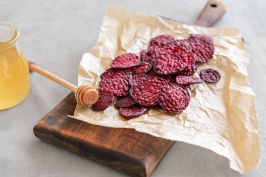 Masa üzerinde lezzetli pancar cips ve bal ile Board