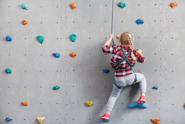 Küçük kız spor salonunda duvar tırmanma