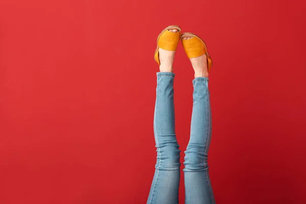 Las piernas de la mujer joven en zapatos elegantes en el fondo de color — Foto de Stock