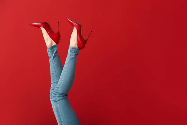 Legs of young woman in high-heeled shoes on color background — Stock Photo, Image