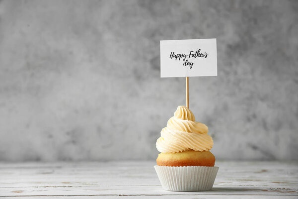 Tasty cupcake for Father's Day on grunge background