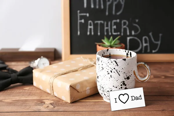 Gift box for father with cup of tea on wooden table