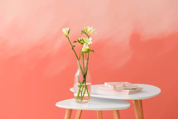 Βάζο με όμορφες φρέζια λουλούδια στο τραπέζι με φόντο το χρώμα — Φωτογραφία Αρχείου