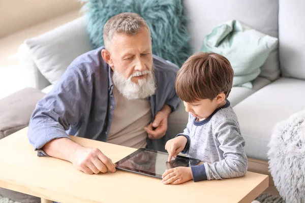 Χαριτωμένο αγοράκι και ο παππούς του με τον υπολογιστή tablet στο σπίτι — Φωτογραφία Αρχείου