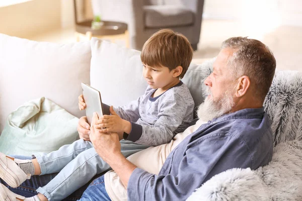 Χαριτωμένο αγοράκι και ο παππούς του με τον υπολογιστή tablet στο σπίτι — Φωτογραφία Αρχείου