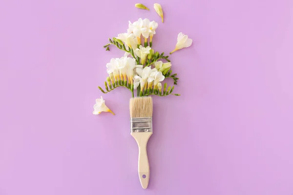 Brush and beautiful freesia flowers on color background — Stock Photo, Image