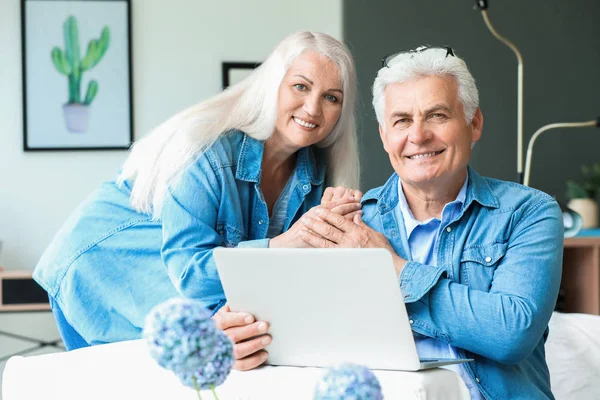 Retrato de casal maduro feliz com laptop em casa — Fotografia de Stock