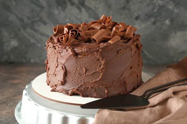 Stand con sabroso pastel de chocolate en la mesa — Foto de Stock