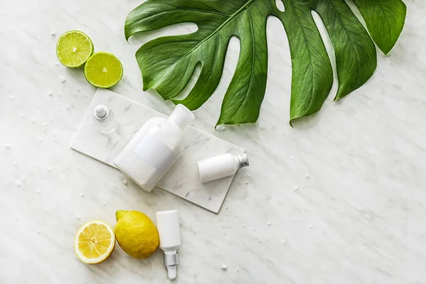 Shampoo, citrusfrugter og tropiske blade på hvid baggrund - Stock-foto